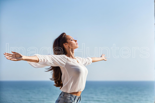 Woman enjoys beach tranquility, breathing in fresh air with arms raised