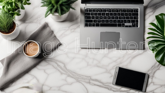 marble study desk adorned with a laptop, coffee, and greenery